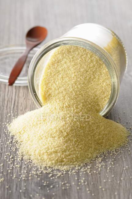 Couscous in an overturned glass jar — Stock Photo