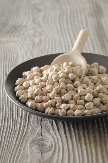 Chickpeas in a bowl with scoop — Stock Photo