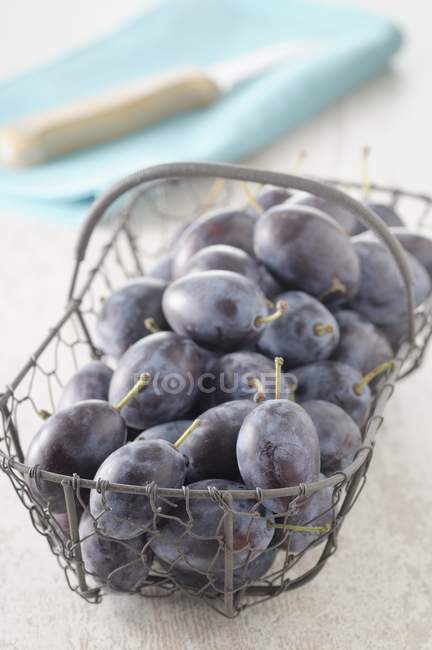 Damsons in wire basket — Stock Photo