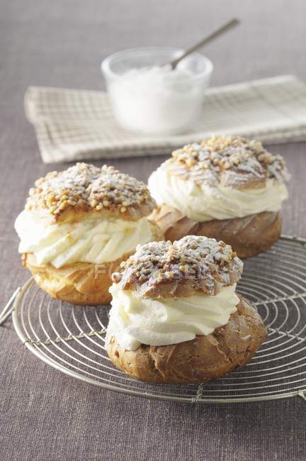 Profiteroles with cream and icing sugar — Stock Photo