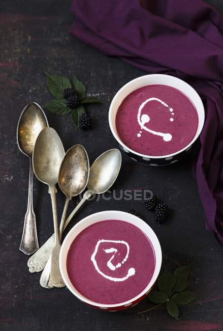Closeup view of blackberry soup with cream in bowls — Stock Photo