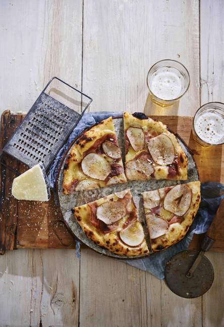 Pizza en una tabla de madera - foto de stock