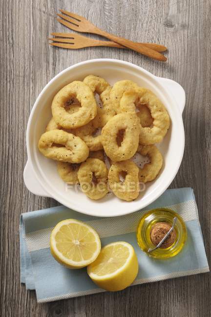 Fried squid rings with lemons — Stock Photo