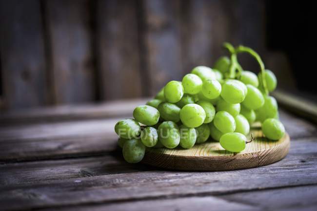 Grüne Trauben auf einem rustikalen Holztisch — Stockfoto