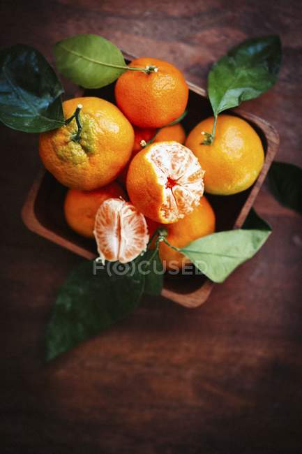 Mandarins with leaves in bowl — Stock Photo