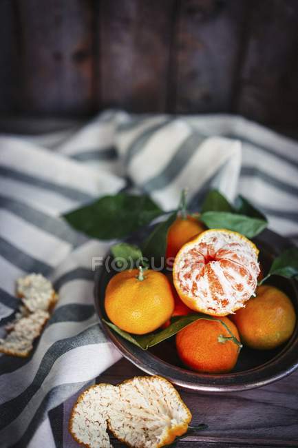 Mandarinas con hojas en un recipiente de metal - foto de stock