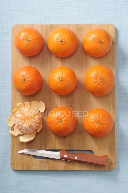 Mandarinas enteras y mandarinas peladas - foto de stock