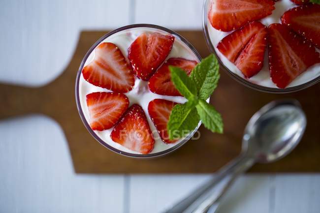 Closeup top view of layered strawberry desserts in glasses — Stock Photo