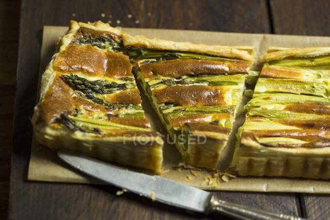 Asparagus tart with a puff pastry base on towel over wooden surface — Stock Photo