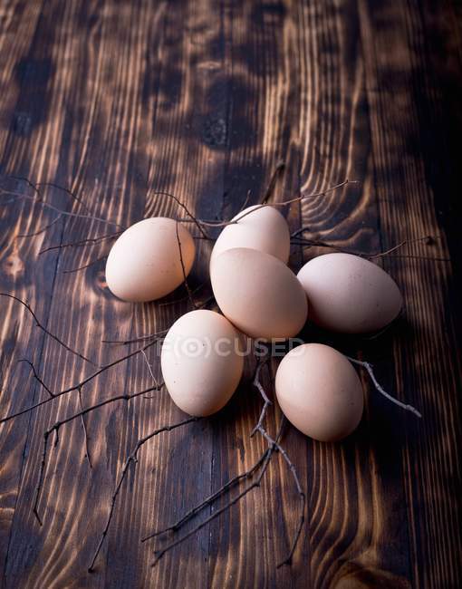 Яйца на темной деревянной поверхности — стоковое фото