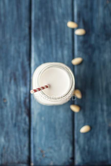 Almond milk in glass with straw — Stock Photo