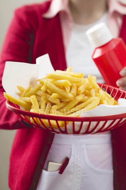 Woman holding french fries — Stock Photo