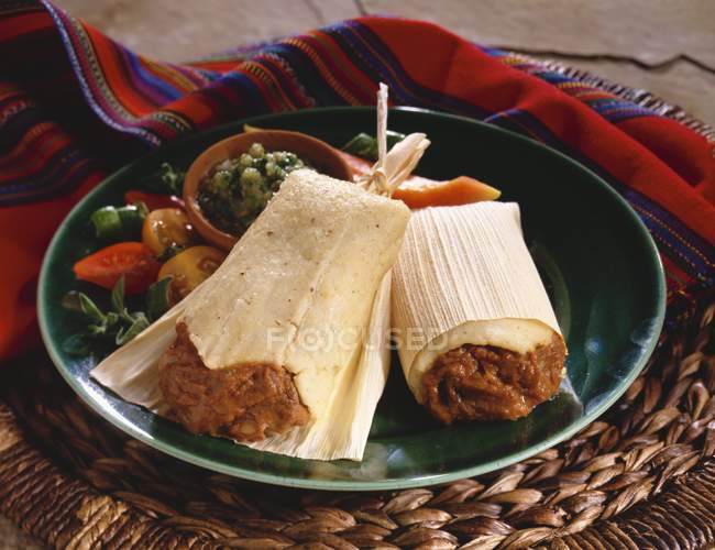 Closeup view of Tamale in husk on a plate — Stock Photo