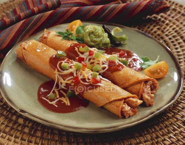 Vue rapprochée de poulet Taquitos avec des sauces sur une assiette — Photo de stock