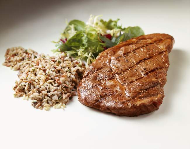 Grilled steak with wild rice — Stock Photo