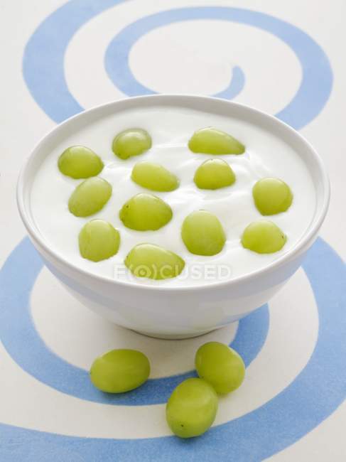 Vista de cerca del yogur natural con uvas verdes - foto de stock