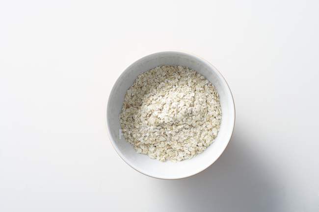 Closeup top view of oats in white bowl — Stock Photo