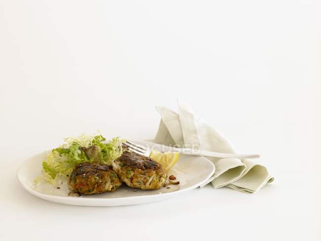 Крабові пиріжки з салатом на тарілці — стокове фото