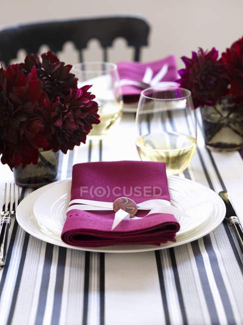 Closeup view of place settings with white plates and pink napkins — Stock Photo