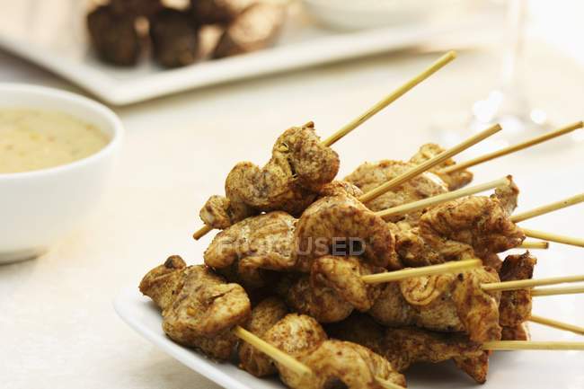 Closeup view of chicken skewers with satay sauce — Stock Photo