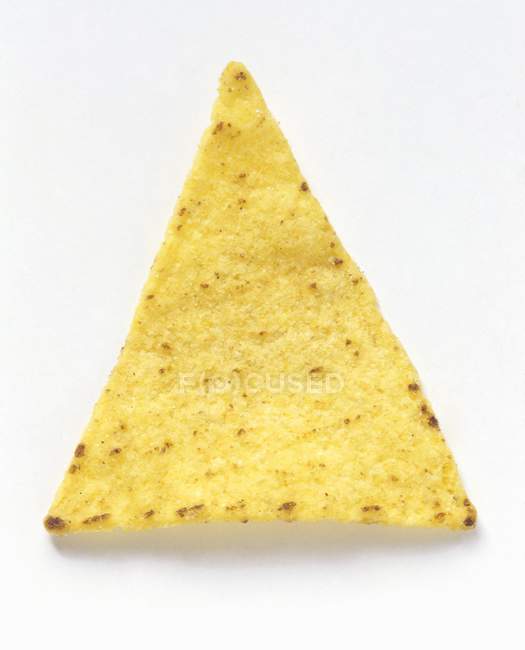 Один чип Tortilla на белой поверхности — стоковое фото