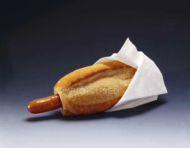 Hot dog with white napkin — Stock Photo
