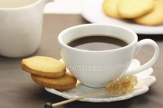 Cup of espresso with candy on stick — Stock Photo