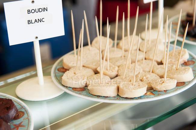 Vue rapprochée de Boudin blanc en tranches avec cure-dents sur un stand de marché — Photo de stock