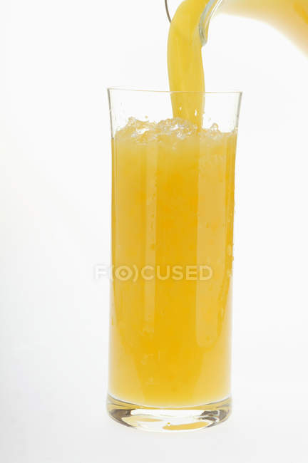Verter jugo de naranja - foto de stock