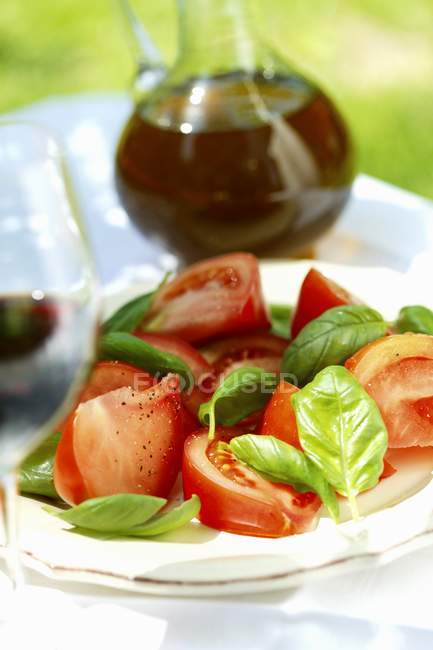 Tomatoes with fresh basil — Stock Photo