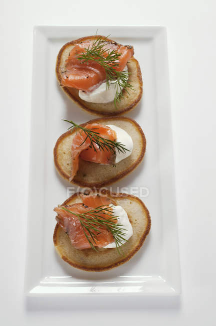 Blinis with salmon and sour cream — Stock Photo