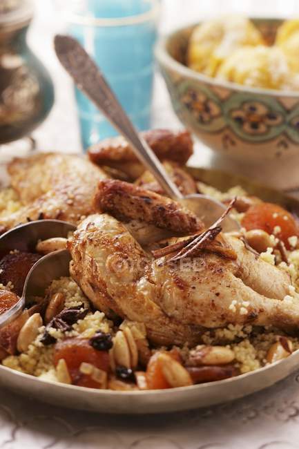 Couscous con pollo sul piatto con cucchiaio — Foto stock