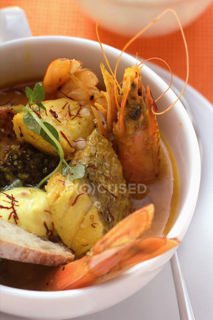 Vista de perto da sopa Bouillabaisse com peixe, camarões e açafrão — Fotografia de Stock