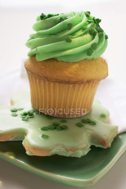 Muffin mit grüner Sahne und Shamrock-Keks — Stockfoto