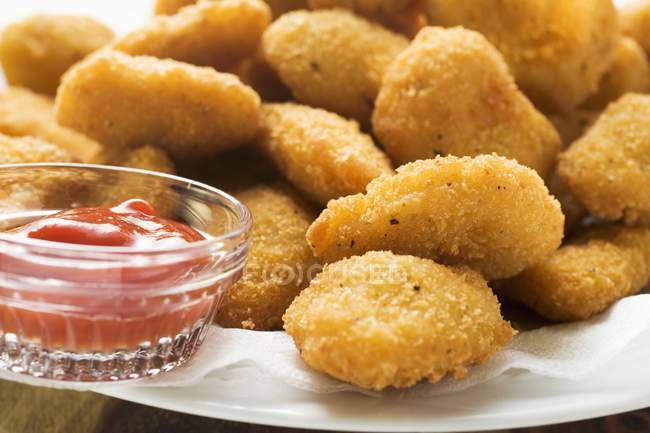 Nuggets de pollo con ketchup en el plato - foto de stock