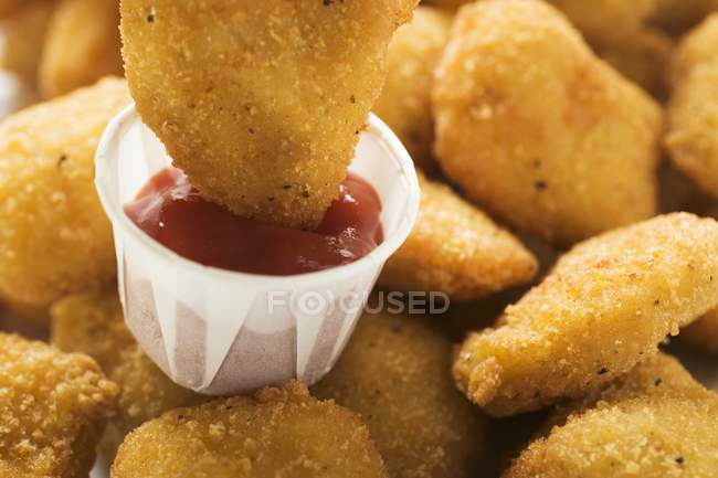 Chicken Nugget in Ketchup tauchen — Stockfoto