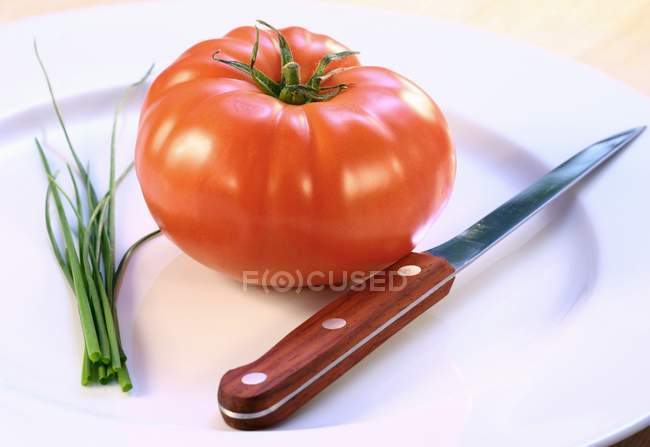 Fresh red tomato and chives — Stock Photo