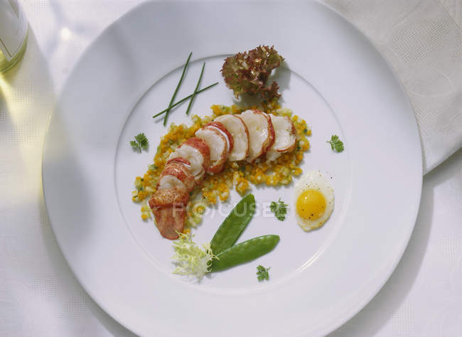 Lobster on lukewarm vegetables on white plate — Stock Photo