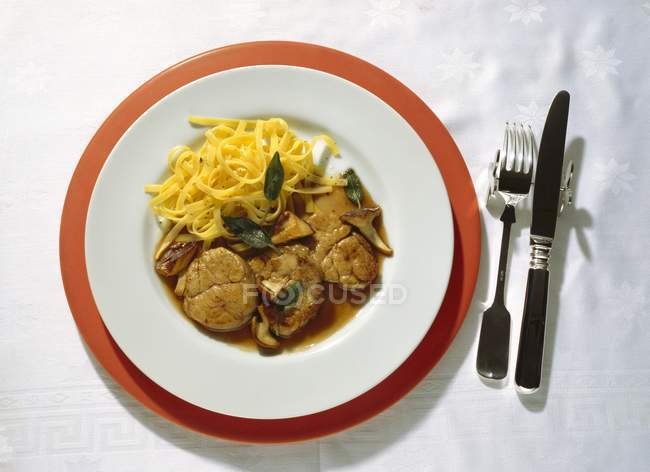 Паста на тарелке с вилкой — стоковое фото