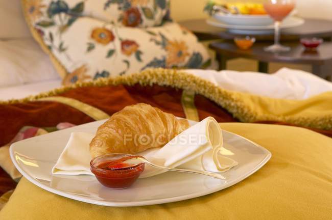 Croissant and jam on a plate — Stock Photo