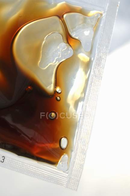 Vista de primer plano de la salsa de soja en envases de plástico - foto de stock