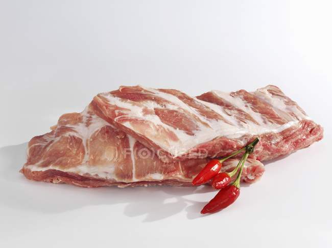 Costillas de cerdo crudas con chiles - foto de stock