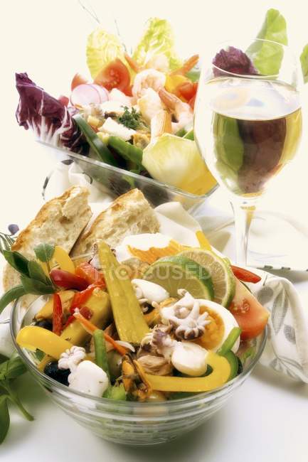 Морепродукти та овочеві салати зі склянкою вина — стокове фото