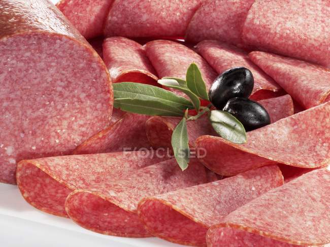 Sliced salami and olives — Stock Photo