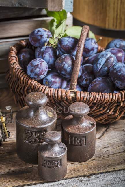 Ameixas frescas colhidas na cesta de vime — Fotografia de Stock