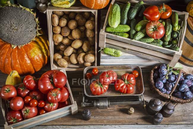 Crates of fresh fruit and vegetables over wooden surface — Stock Photo
