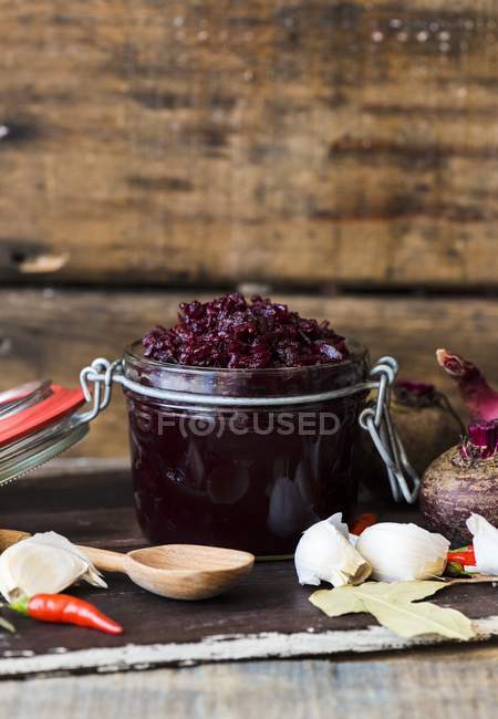 A jar of beetroot relish over wooden background — Stock Photo