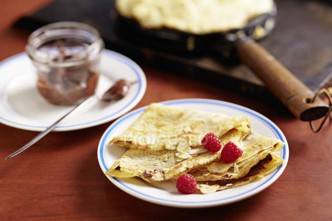 Closeup view of crepes with raspberries and chocolate cream — Stock Photo