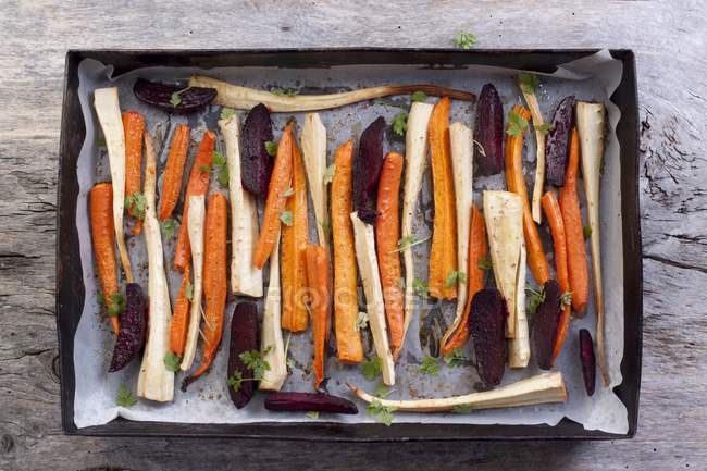 Légumes-racines rôtis et betteraves sur une plaque à pâtisserie — Photo de stock