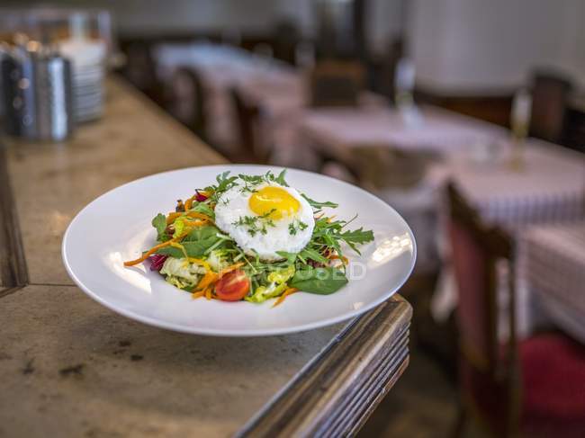 Mixed salad with fried egg on plate — Stock Photo